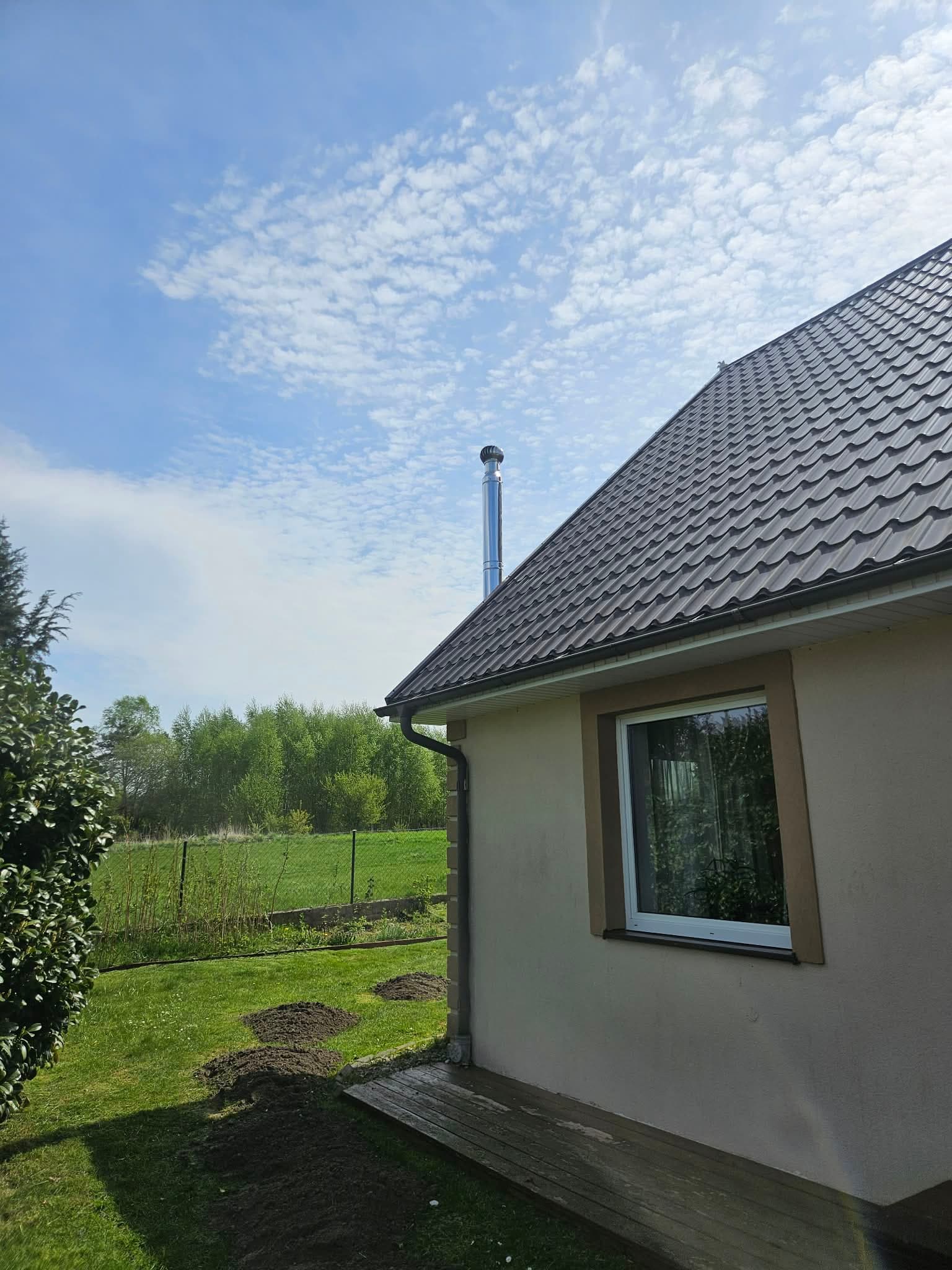Komin izolowany z nasadą obrotową na elewacji domu jednorodzinnego